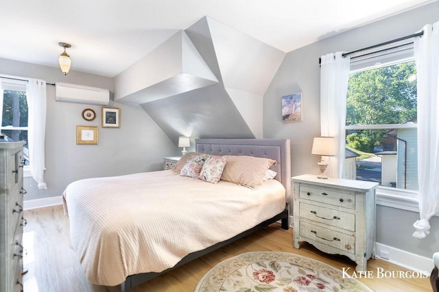 140 S Monroe St NE, Rockford, MI 49341 - bedroom featuring a wall mounted air conditioner, light wood-type flooring, and vaulted ceiling