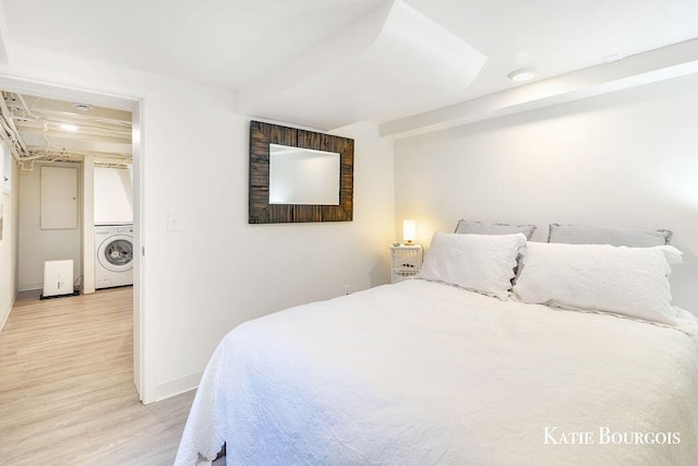 140 S Monroe St NE, Rockford, MI 49341 - bedroom featuring stacked washer / drying machine and light wood-style flooring