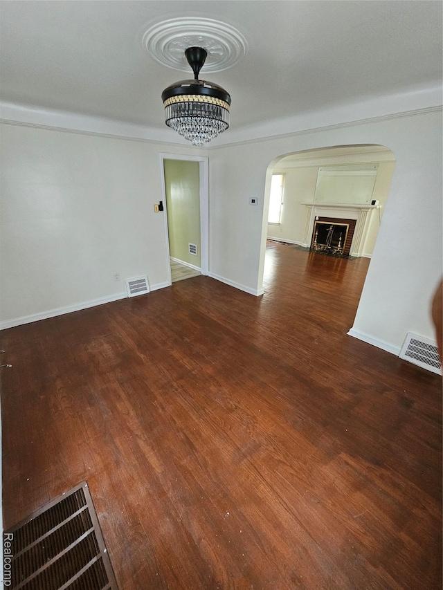 15900 Murray Hill St, Detroit, MI 48227 - unfurnished living room featuring arched walkways, wood finished floors, a fireplace, and crown molding