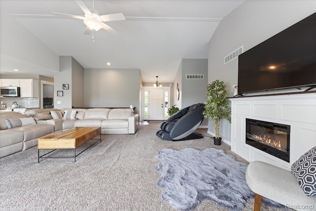 5606 Chatham Ln, Grand Blanc, MI 48439 - carpeted living area featuring ceiling fan, a glass covered fireplace, and high vaulted ceiling