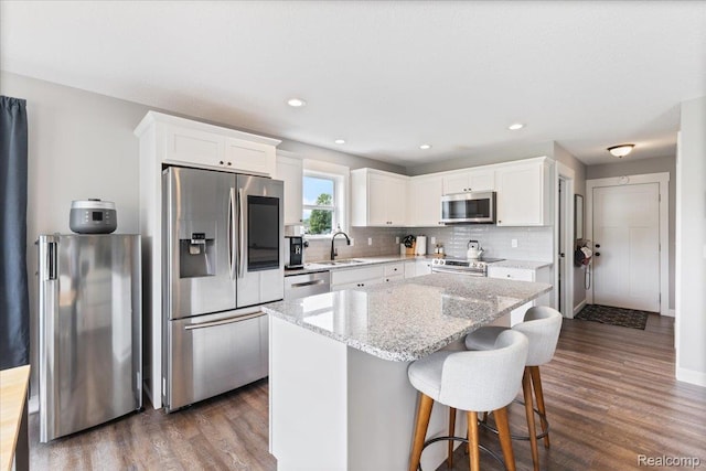 5606 Chatham Ln, Grand Blanc, MI 48439 - kitchen featuring appliances with stainless steel finishes, dark wood-style floors, white cabinetry, backsplash, and recessed lighting