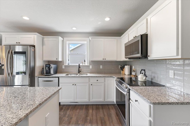 5606 Chatham Ln, Grand Blanc, MI 48439 - kitchen featuring stainless steel appliances, white cabinetry, dark wood-type flooring, backsplash, and recessed lighting