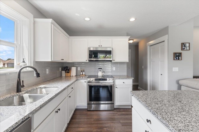 5606 Chatham Ln, Grand Blanc, MI 48439 - kitchen with stainless steel appliances, backsplash, dark wood-style flooring, white cabinets, and recessed lighting