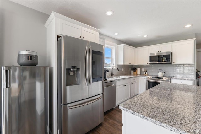 5606 Chatham Ln, Grand Blanc, MI 48439 - kitchen featuring stainless steel appliances, white cabinets, light stone counters, and recessed lighting