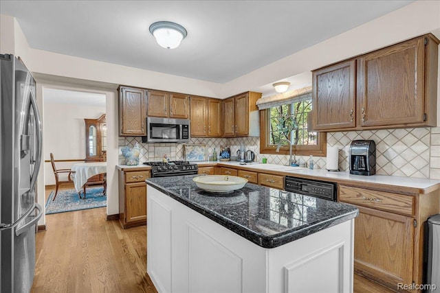 24842 White Plains Dr, Novi, MI 48374 - kitchen featuring appliances with stainless steel finishes, light wood-style flooring, backsplash, and a kitchen island