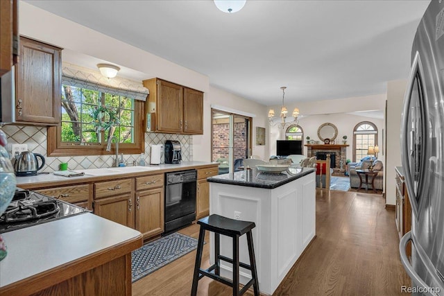 24842 White Plains Dr, Novi, MI 48374 - kitchen featuring dishwasher, open floor plan, light wood finished floors, backsplash, and freestanding refrigerator