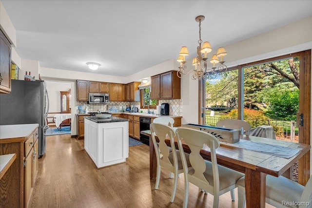24842 White Plains Dr, Novi, MI 48374 - kitchen featuring stainless steel appliances, wood finished floors, a chandelier, a center island, and tasteful backsplash