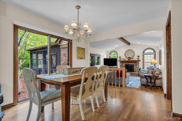 24842 White Plains Dr, Novi, MI 48374 - dining area with a chandelier, light wood-type flooring, and a fireplace with raised hearth