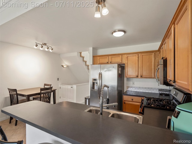35033 Windsor Dr, New Baltimore, MI 48047 - kitchen with stainless steel appliances, dark countertops, light tile patterned flooring, a peninsula, and brown cabinetry