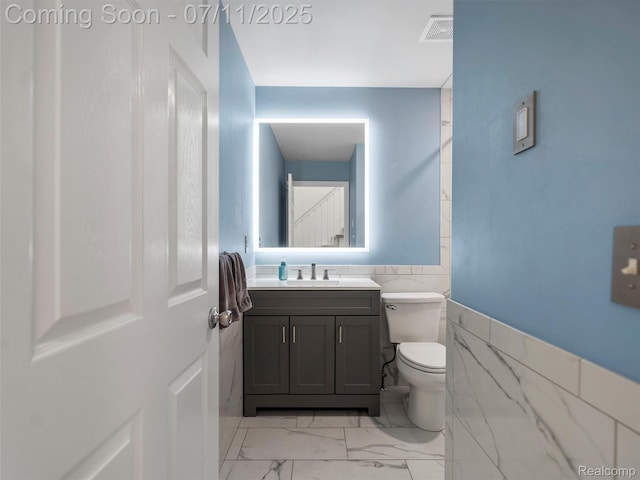 35033 Windsor Dr, New Baltimore, MI 48047 - half bathroom with vanity, marble finish flooring, tile walls, and a wainscoted wall