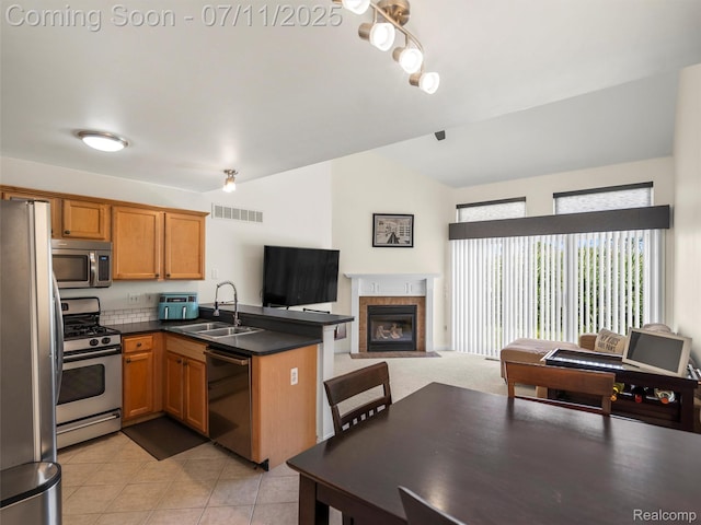 35033 Windsor Dr, New Baltimore, MI 48047 - kitchen featuring stainless steel appliances, a peninsula, open floor plan, vaulted ceiling, and dark countertops