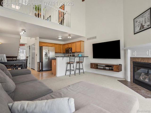 35033 Windsor Dr, New Baltimore, MI 48047 - living area featuring a towering ceiling, light carpet, and a tiled fireplace