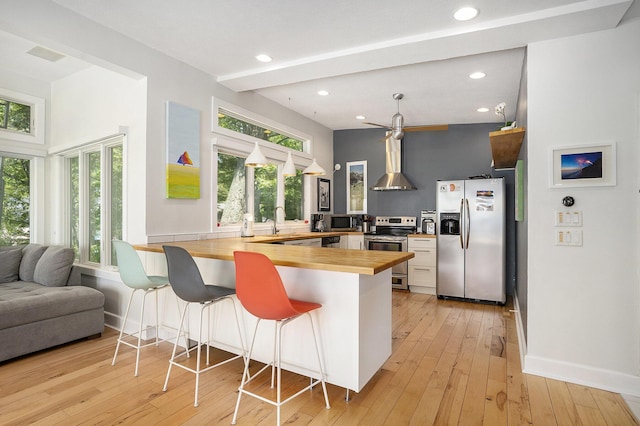 6881 Helena St, West Olive, MI 49460 - kitchen with wooden counters, stainless steel appliances, a peninsula, healthy amount of natural light, and recessed lighting