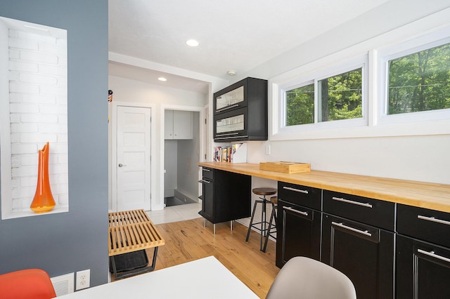 6881 Helena St, West Olive, MI 49460 - kitchen featuring dark cabinets, plenty of natural light, light wood finished floors, recessed lighting, and butcher block countertops