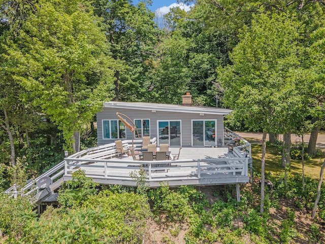 6881 Helena St, West Olive, MI 49460 - rear view of house featuring a chimney, a deck, and outdoor dining space
