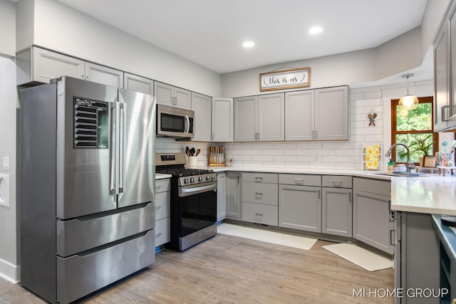 3255 Prairie St SW, Grandville, MI 49418 - kitchen with appliances with stainless steel finishes, gray cabinetry, light countertops, decorative backsplash, and recessed lighting