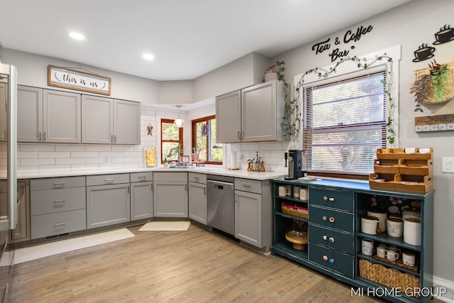 3255 Prairie St SW, Grandville, MI 49418 - kitchen featuring stainless steel dishwasher, gray cabinets, tasteful backsplash, light wood-type flooring, and light countertops