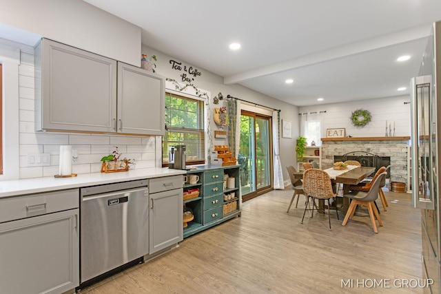 3255 Prairie St SW, Grandville, MI 49418 - kitchen with stainless steel dishwasher, gray cabinetry, light wood finished floors, light countertops, and backsplash