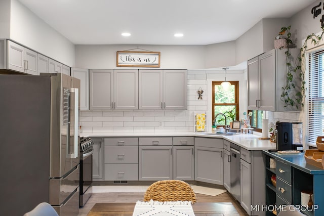 3255 Prairie St SW, Grandville, MI 49418 - kitchen with appliances with stainless steel finishes, gray cabinetry, decorative backsplash, light wood-type flooring, and recessed lighting