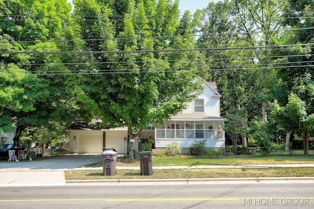 3255 Prairie St SW, Grandville, MI 49418 - view of property hidden behind natural elements featuring driveway, an attached garage, a front lawn, a shingled roof, and a sunroom