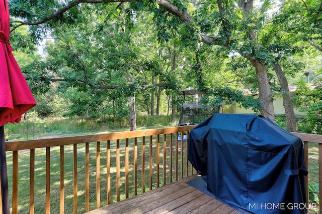3255 Prairie St SW, Grandville, MI 49418 - wooden deck featuring area for grilling, a lawn, and view of wooded area