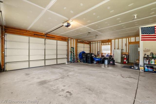 5037 Scheuners Way, Howell, MI 48843 - garage with a garage door opener and freestanding refrigerator