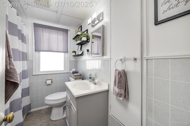 8600 Saratoga St, Oak Park, MI 48237 - full bathroom featuring tile walls, vanity, tile patterned flooring, a drop ceiling, and a wainscoted wall