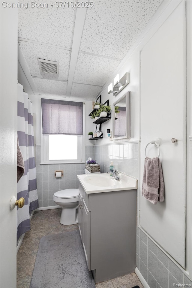 8600 Saratoga St, Oak Park, MI 48237 - full bathroom with tile walls, vanity, a shower with curtain, and a wainscoted wall