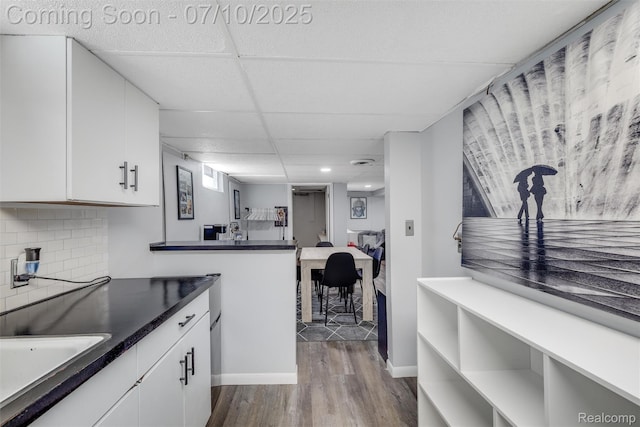 8600 Saratoga St, Oak Park, MI 48237 - kitchen with dark wood-style flooring, white cabinets, dark countertops, decorative backsplash, and recessed lighting
