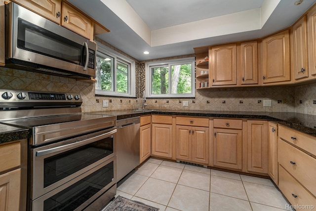 4729 Curtis Ln, Clarkston, MI 48346 - kitchen with stainless steel appliances, tile countertops, light tile patterned floors, tasteful backsplash, and a raised ceiling