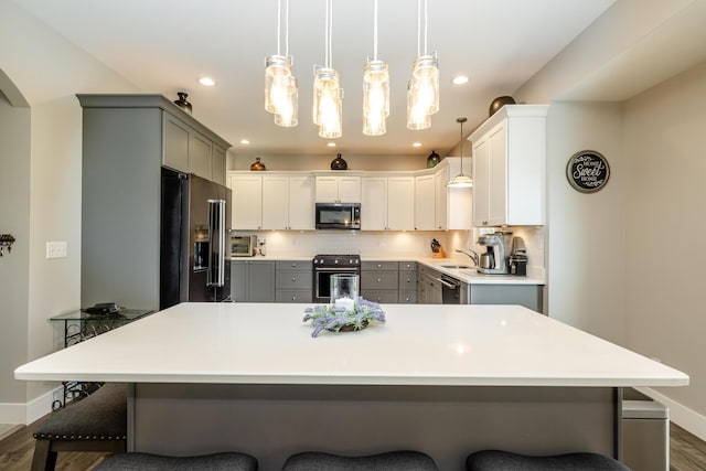 4785 Lauren Ln, Saint Joseph, MI 49085 - kitchen with stainless steel appliances, gray cabinets, a kitchen breakfast bar, dark wood-type flooring, and recessed lighting