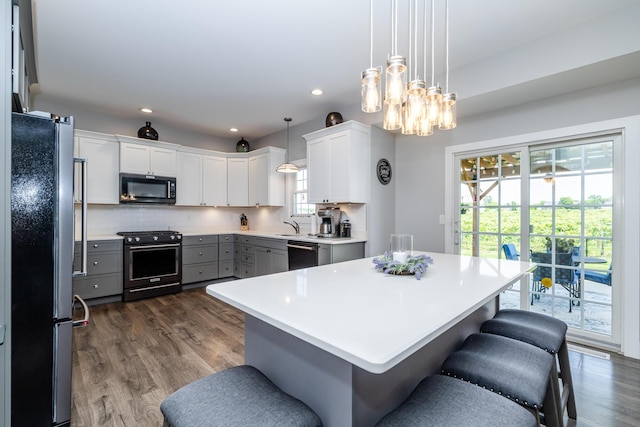 4785 Lauren Ln, Saint Joseph, MI 49085 - kitchen with black appliances, gray cabinetry, dark wood-type flooring, tasteful backsplash, and light countertops