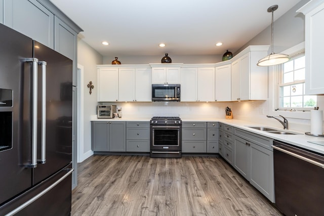 4785 Lauren Ln, Saint Joseph, MI 49085 - kitchen with appliances with stainless steel finishes, gray cabinetry, wood finished floors, backsplash, and light countertops