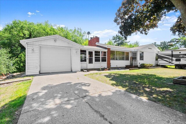 3658 Lake Harbor Rd, Norton Shores, MI 49441 - single story home with a front yard, a chimney, a sunroom, a garage, and concrete driveway