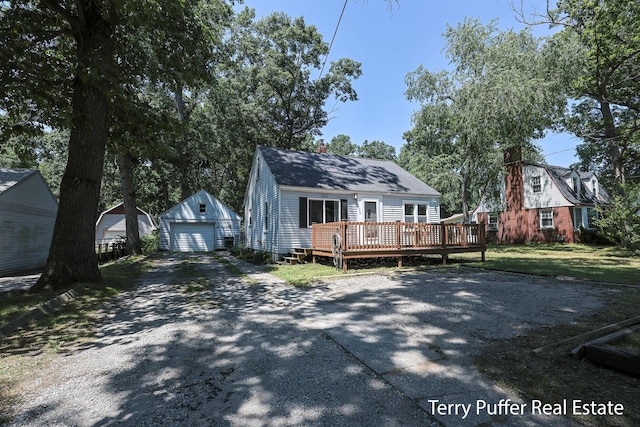 2025 Whitehall Rd, Muskegon, MI 49445 - view of front facade featuring an outbuilding, a wooden deck, a detached garage, driveway, and a chimney