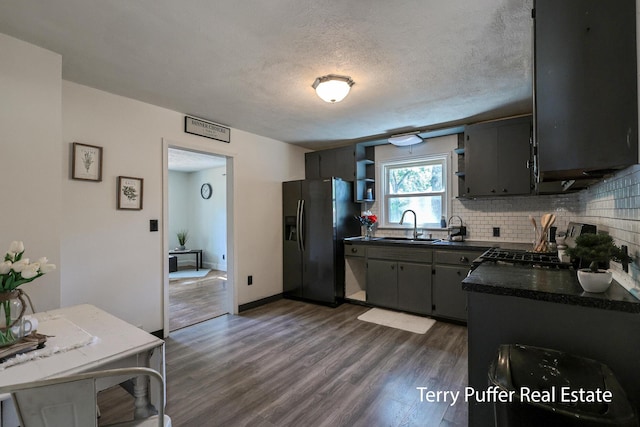 2025 Whitehall Rd, Muskegon, MI 49445 - kitchen featuring refrigerator with ice dispenser, dark countertops, tasteful backsplash, dark wood-style floors, and a textured ceiling