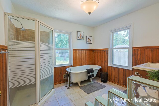 2025 Whitehall Rd, Muskegon, MI 49445 - bathroom featuring a wainscoted wall, a stall shower, wooden walls, healthy amount of natural light, and a freestanding tub