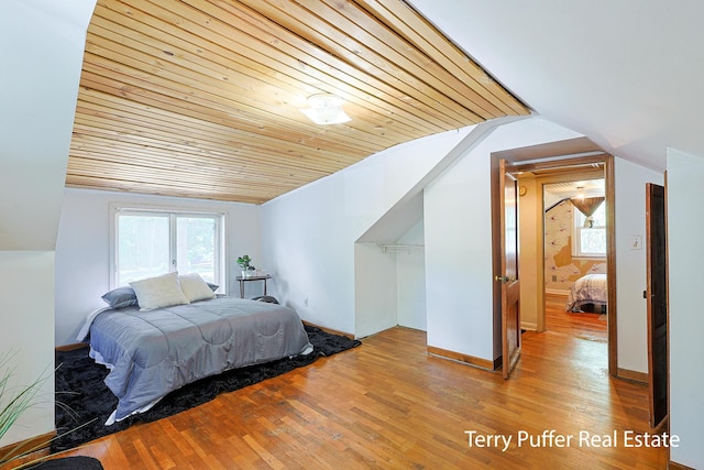 2025 Whitehall Rd, Muskegon, MI 49445 - bedroom with vaulted ceiling, multiple windows, and wood finished floors