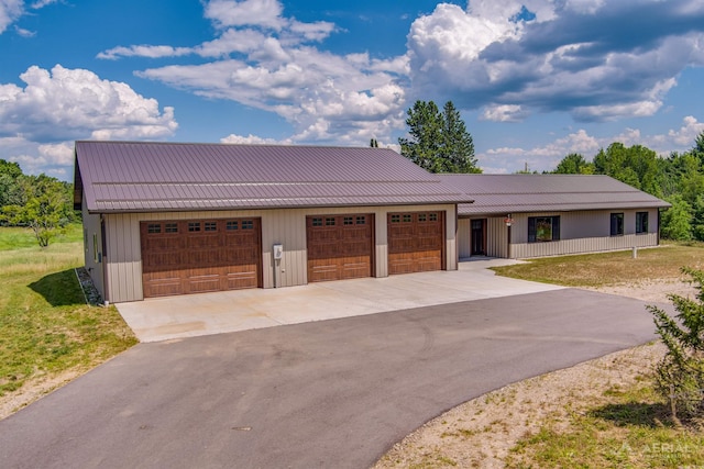 4646 Lehman Rd, West Branch, MI 48661 - view of front of property with a metal roof, driveway, an attached garage, and a standing seam roof