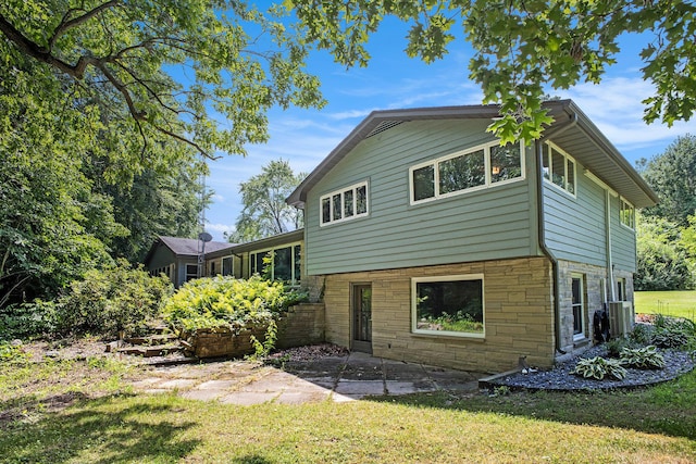 929 N Park Rd, Benton Harbor, MI 49022 - back of house featuring stone siding, a patio area, and a lawn