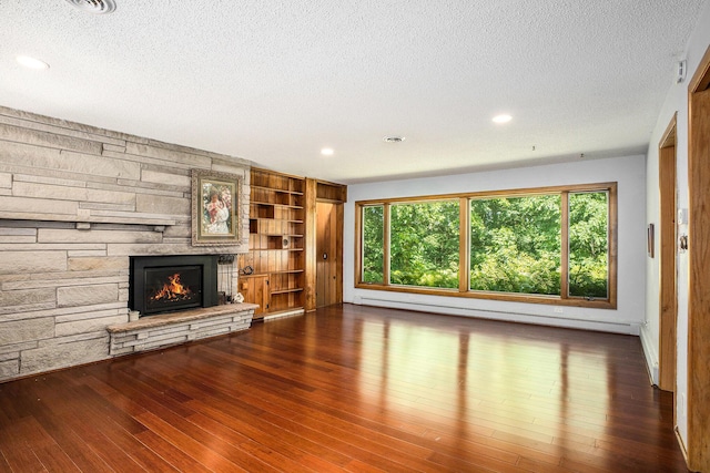 929 N Park Rd, Benton Harbor, MI 49022 - unfurnished living room with a textured ceiling, a baseboard radiator, a fireplace, wood finished floors, and recessed lighting