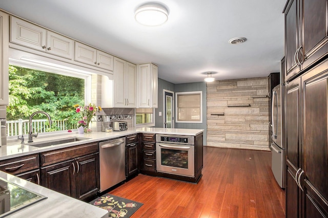 929 N Park Rd, Benton Harbor, MI 49022 - kitchen featuring stainless steel appliances, light countertops, dark brown cabinetry, wooden walls, and dark wood-type flooring