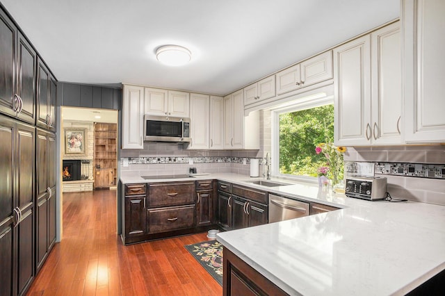 929 N Park Rd, Benton Harbor, MI 49022 - kitchen featuring stainless steel appliances, dark brown cabinets, decorative backsplash, and dark wood-style floors