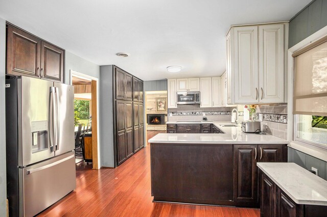 929 N Park Rd, Benton Harbor, MI 49022 - kitchen featuring appliances with stainless steel finishes, dark brown cabinets, decorative backsplash, and wood finished floors