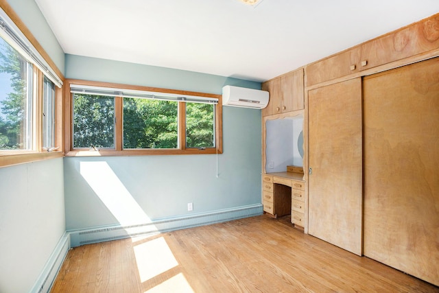 929 N Park Rd, Benton Harbor, MI 49022 - unfurnished bedroom with a wall unit AC, light wood-style flooring, and a closet