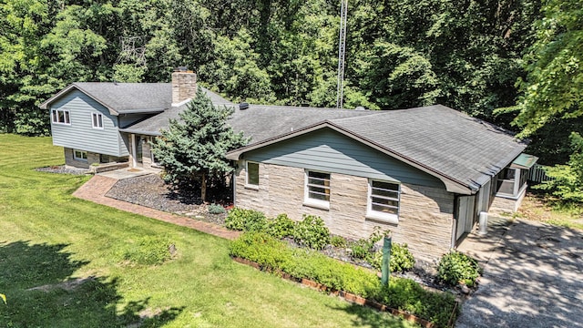929 N Park Rd, Benton Harbor, MI 49022 - view of front of home featuring stone siding, a chimney, a front yard, and roof with shingles