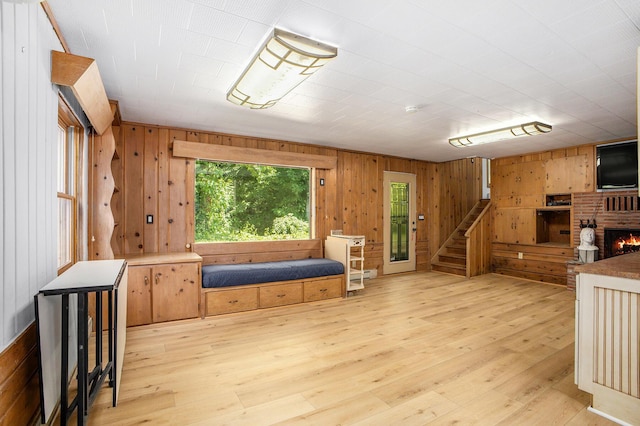 929 N Park Rd, Benton Harbor, MI 49022 - sitting room with wood walls, stairs, light wood-style flooring, and a fireplace