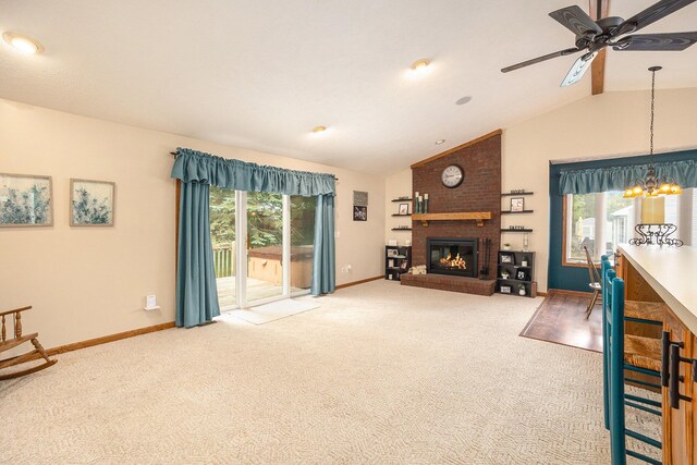 1972 Red Pine Dr, Dorr, MI 49323 - carpeted living room featuring lofted ceiling, a brick fireplace, a chandelier, and a ceiling fan