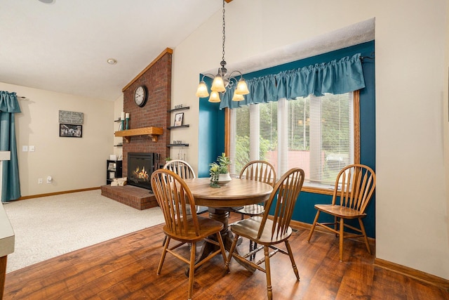 1972 Red Pine Dr, Dorr, MI 49323 - dining area featuring a chandelier, a brick fireplace, wood finished floors, and high vaulted ceiling