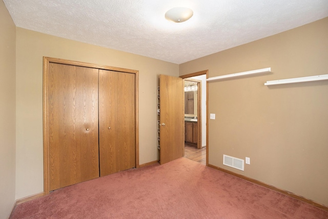 1972 Red Pine Dr, Dorr, MI 49323 - unfurnished bedroom featuring a closet, carpet floors, and a textured ceiling